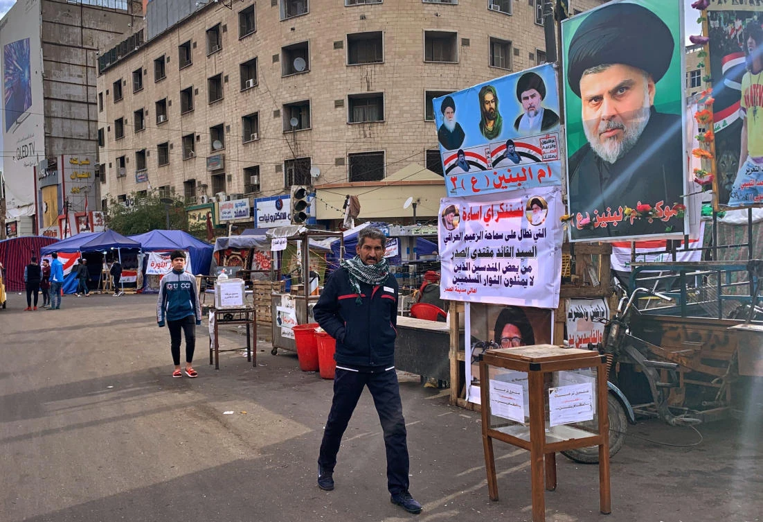 A poster of Shiite cleric Muqtada Al-Sadr, right, is hung in Tahrir Square during ongoing anti-government protests in Baghdad. (AP)