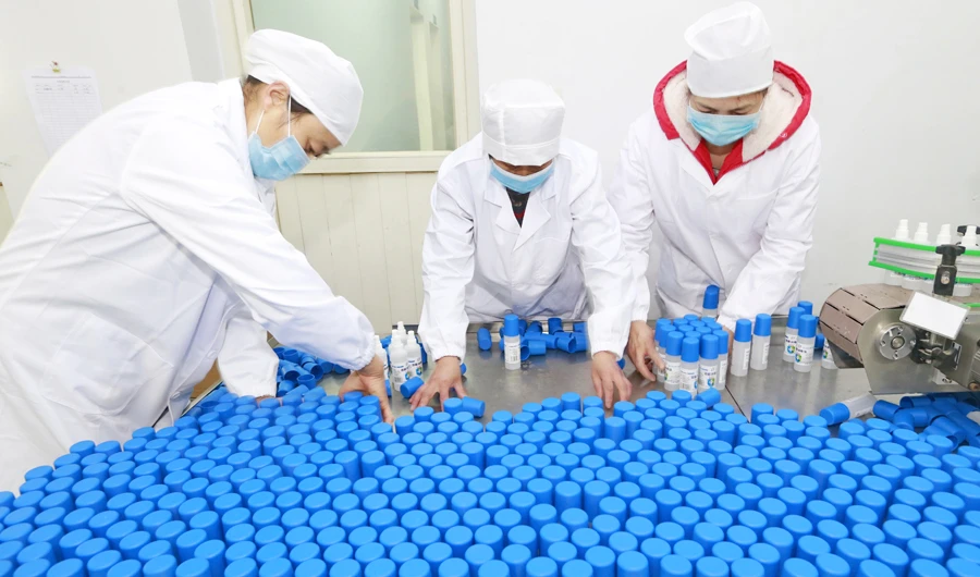Workers pack bottles of alcohol disinfectant in a factory in Suining in southwest China's Sichuan province Tuesday, Feb. 11, 2020. (AP)