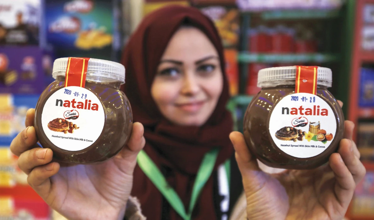 A shop employee holds up jars of the Gazan-produced ‘Natalia’. (AFP)