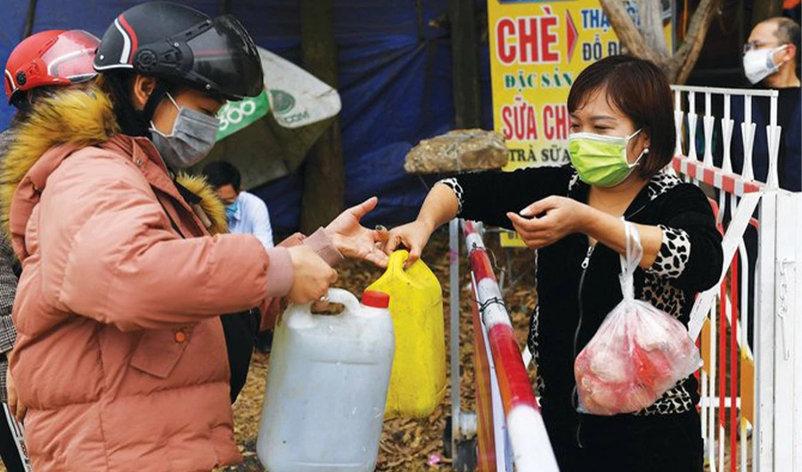 Local residents wearing protective face masks amid fears coronavirus pass containers of petrol across a checkpoint in Vietnam. Alarm over coronavirus has hit Asia’s economies. Shutterstock Villages in Vietnam with 10,000 people close to the nation’s capital were placed under quarantine on February 13 after six cases of the deadly new coronavirus were discovered there, authorities said. (Nhac Nguyen / AFP)