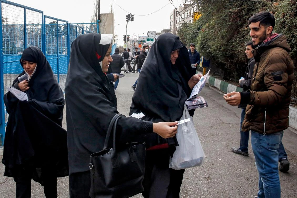 Campaigners hand out electoral leaflets to people outside a mosque in the Iranian capital Tehran on Feb. 14, 2020. (AFP)