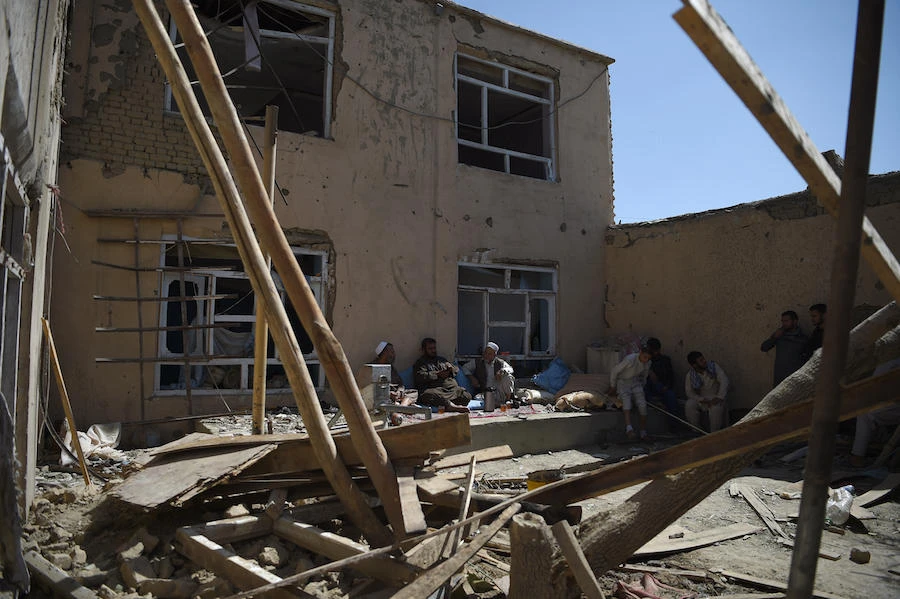 Afghan residents sit in a damaged courtyard as they drink tea following a NATO airstrike on a house in Kabul. (File/AFP)