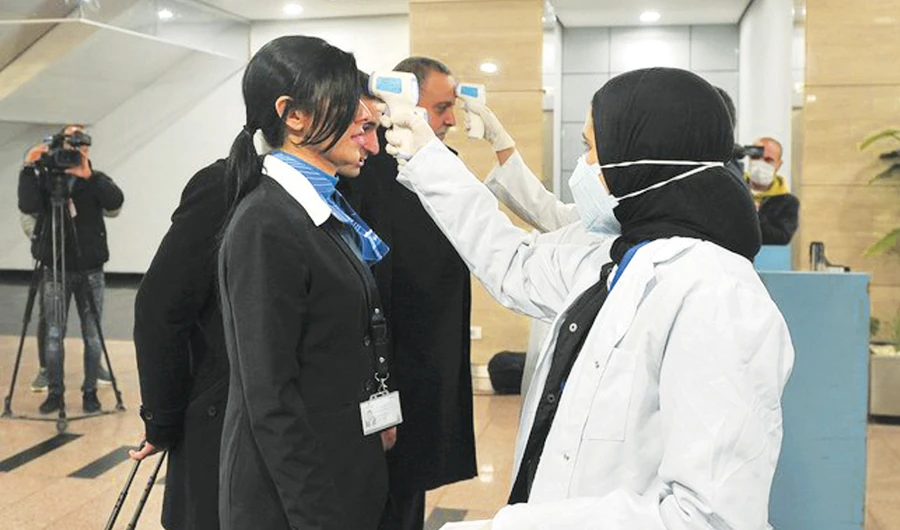Egyptian Quarantine Authority employees prepare to scan body temperatures of incoming travelers at Cairo International Airport. (AFP)