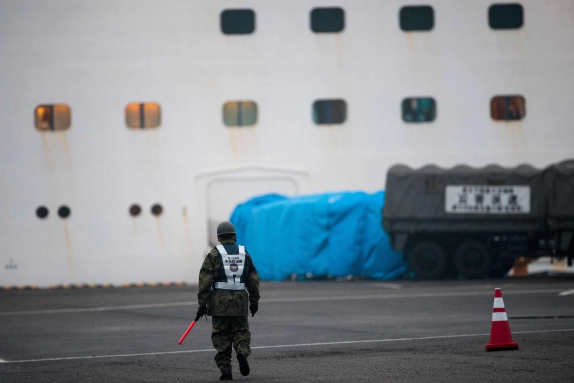 A member of the Japan Self-Defense Forces walks next to the Diamond Princess cruise ship, where people are quarantined onboard due to fears of the new COVID-19 coronavirus, at the Daikaku Pier Cruise Terminal in Yokohama port, on February 16, 2020. (AFP)