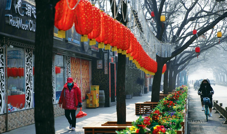 The untouched Lunar New Year decor and the shuttered bars in a retail district in Beijing reflect the wider impact of the national curbs on business. (AP)