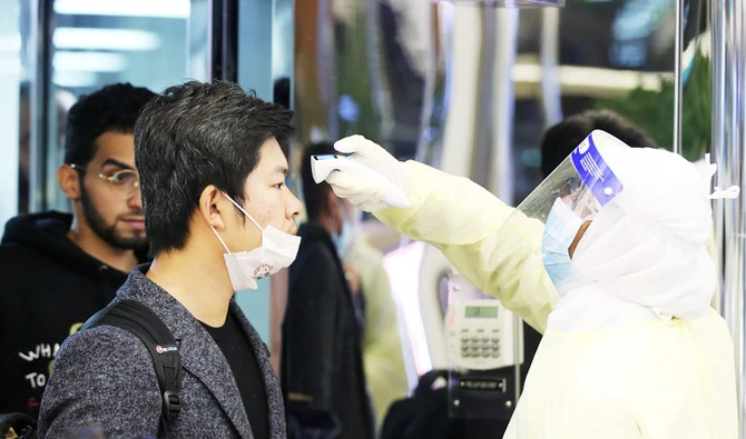 Passengers from China wearing masks to prevent a new coronavirus are checked by Saudi Health Ministry employees upon their arrival at King Khalid International Airport, in Riyadh, Saudi Arabia January 29, 2020. (REUTERS)