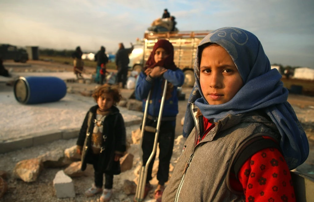 Syrian children prepare to flee a camp for the displaced, east of Sarmada in the north of the northwestern Idlib province, on February 16, 2020, amid an ongoing pro-regime offensive. (AFP)