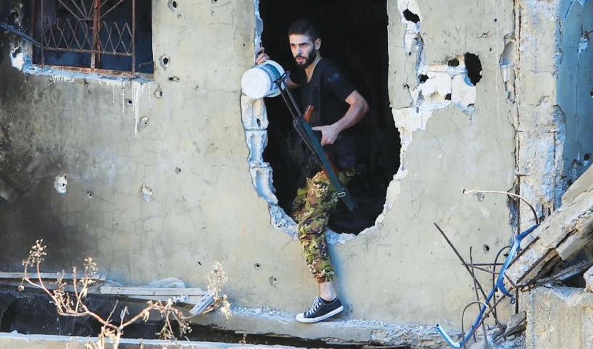 A Palestinian fighter walks through a hole in a wall inside the Ain El-Hilweh refugee camp near Sidon, southern Lebanon. (Reuters/File)