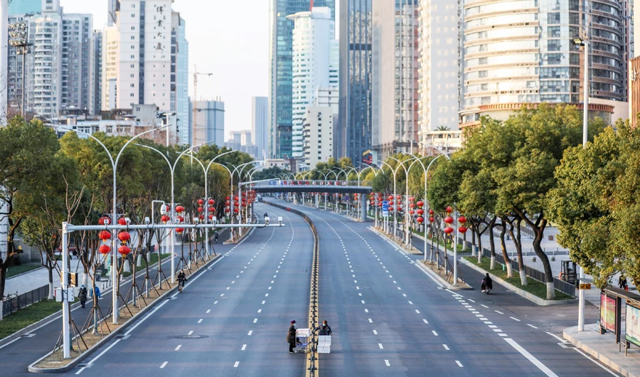 This photo taken on February 20, 2020 shows two staff members crossing an empty road as they deliver vegetables to a hospital in Wuhan in China's central Hubei province. (AFP)