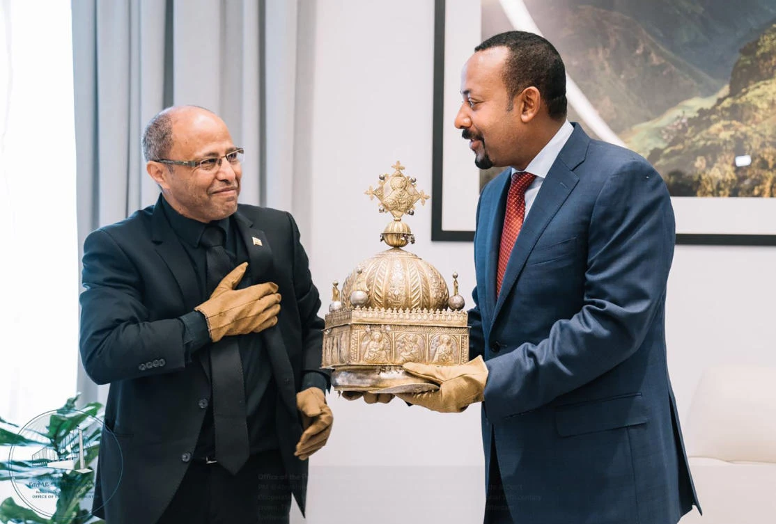A picture obtained from the Twitter account of the Office of the Prime Minister of Ethiopia Abiy Ahmed shows Ethiopian Prime minister Abiy Ahmed (R) meeting with Sirak Asfaw (L), who had kept hidden in his appartment in the Netherlands a 18th-century crown for two decades, during a ceremony to hand over the crown in Addis Ababa on February 20, 2020. (AFP)