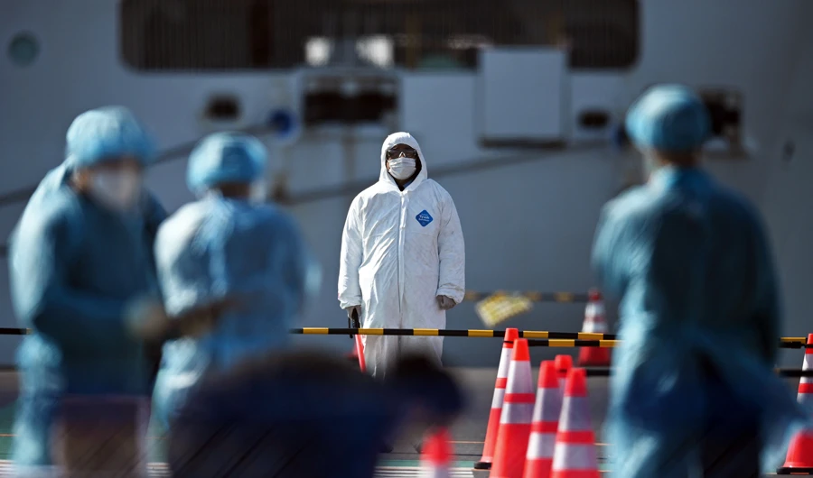 Workers in protective clothing in Yokohama alongside the Diamond Princess cruise ship, where passengers have been held in quarantine after the coronavirus outbreak on board. (AFP)