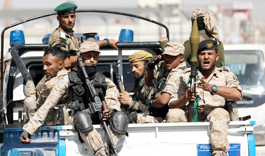 Iranian-backed militants ride on the back of a police patrol truck after participating in a Houthi gathering in Sanaa, as Yemen’s legitimage government tightens security measures. (Reuters)
