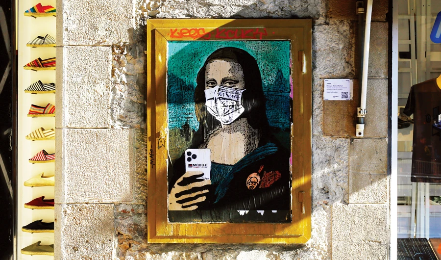 A poster on a Barcelona street by Italian urban artist Salvatore Benintende shows Leonardo da Vinci’s Mona Lisa wearing a protective facemask. (AFP)