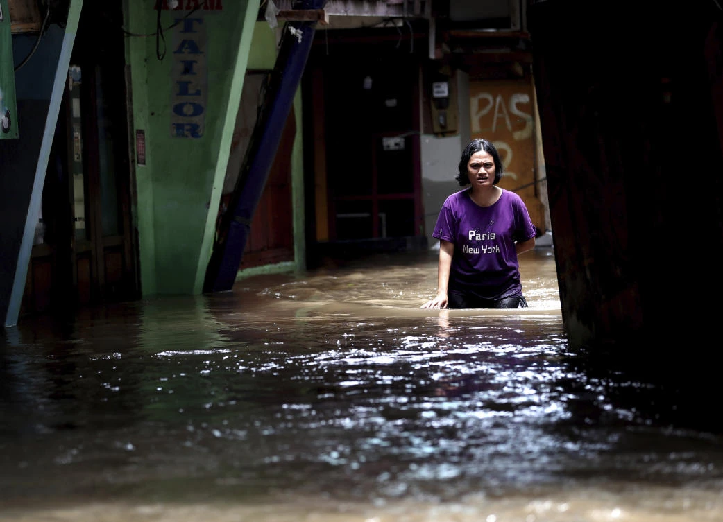 A woman wades through water in a flooded neighborhood in Jakarta, Indonesia, Tuesday, Feb. 25, 2020. (AP)