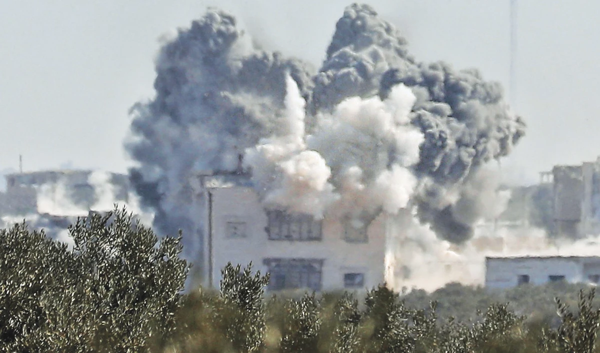 Smoke billows above buildings during an airstrike by regime forces on the village of Nayrab, about 14 km southeast of Idlib in northwestern Syria. (AFP)
