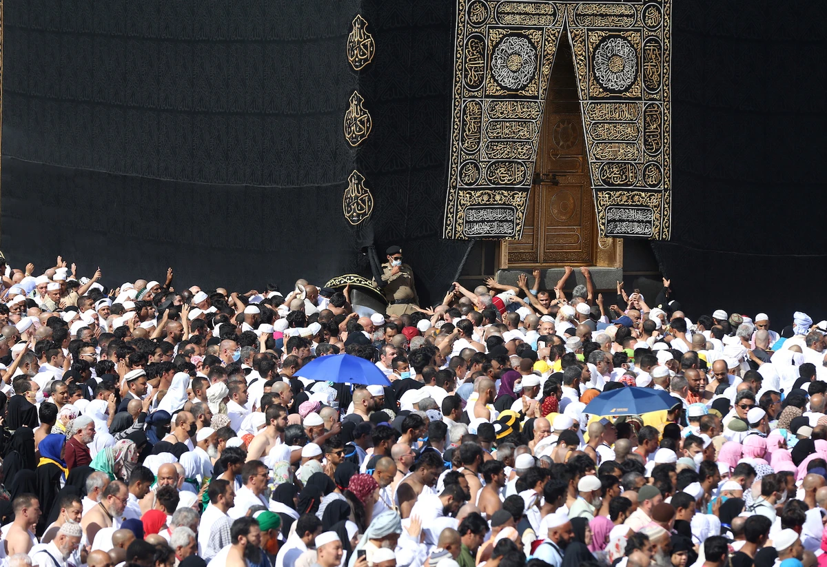 A police officer wears a face mask to prevent contracting coronavirus as Muslim pilgrims pray near the Kaaba in the Grand mosque in Makkah, Saudi Arabia on Feb. 27, 2020. (Reuters)