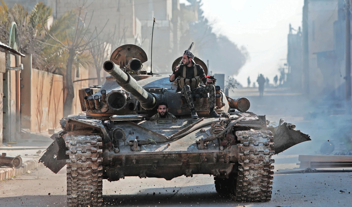 Turkey-backed Syrian fighters ride a tank in the town of Saraqib in the eastern part of the Idlib province in northwestern Syria, as fierce fighting raged on in its outskirts on Thursday. (AFP)