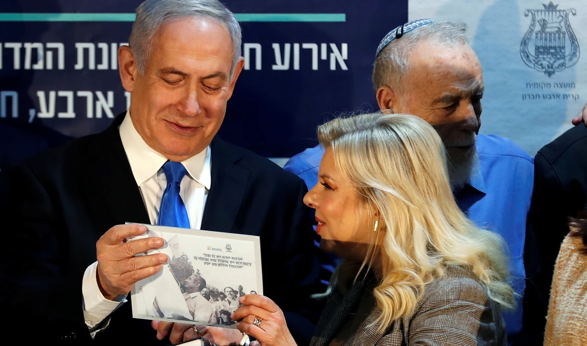 Israeli Prime Minister Benjamin Netanyahu and his wife Sara smile after receiving a gift during an event inaugurating a new neighborhood in Kiryat Arba, a Jewish settlement in Hebron in the Israeli-occupied West Bank. (Reuters)