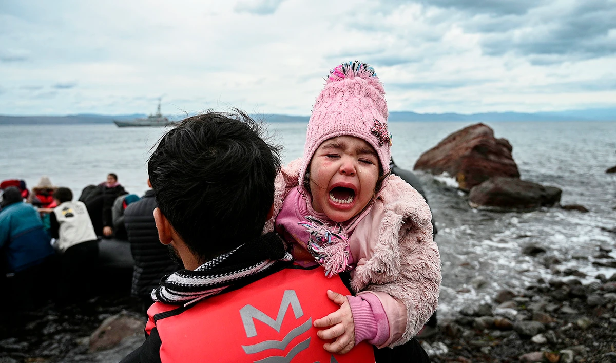 A child cries as a dinghy with 54 Afghan refugees lands ashore the Greek island of Lesbos on February 28, 2020. (AFP)