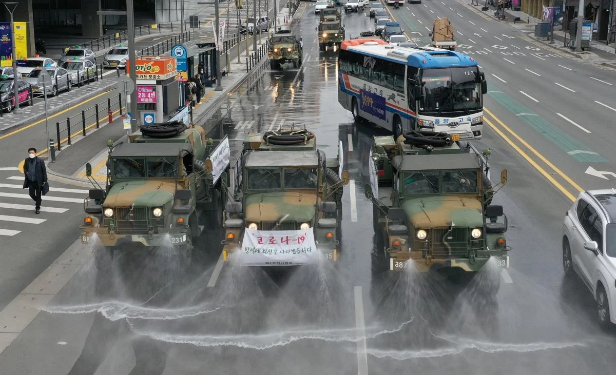 Military vehicles spray disinfectant as part of preventive measures against the spread of the COVID-19 coronavirus, on a road near Dongdaegu railway station in Daegu on Feb. 29, 2020. (AFP)