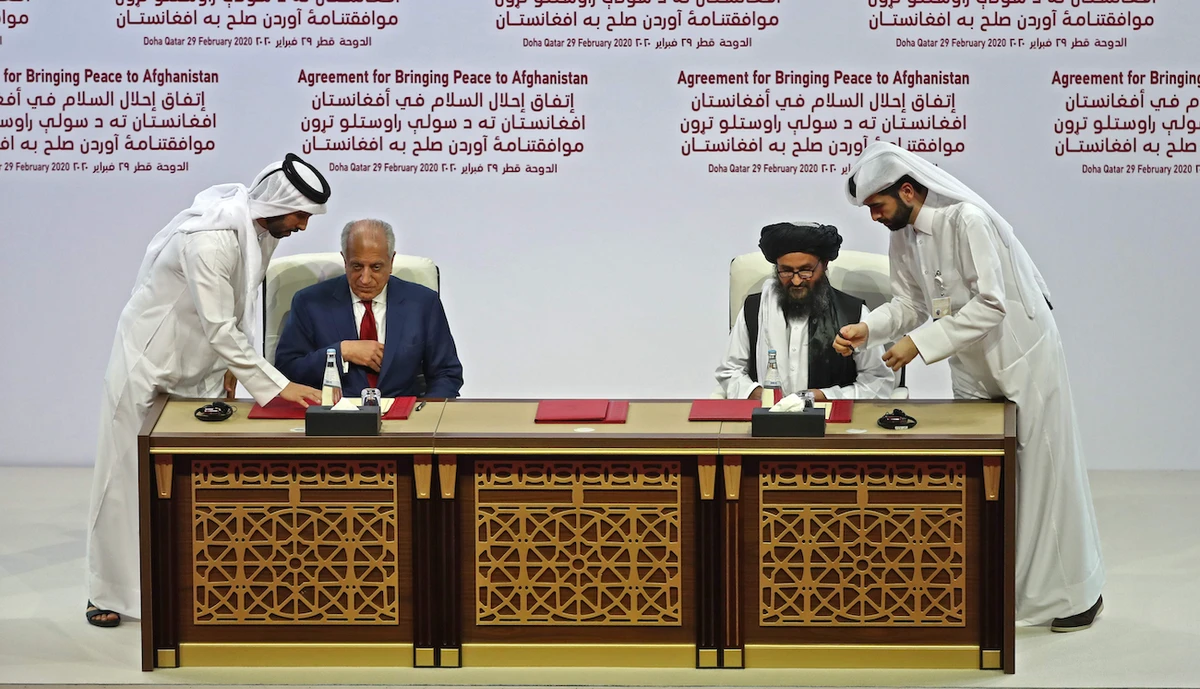 US Special Representative for Afghanistan Reconciliation Zalmay Khalilzad and Taliban co-founder Mullah Abdul Ghani Baradar sign the US-Taliban peace agreement during a ceremony in the Qatari capital Doha on Feb. 29, 2020. (AFP)