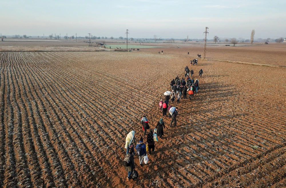 Migrants walk towards Greece along the Turkey-Greece border near Pazarkule, in Edirne district, on March 1, 2020. Turkey will no longer close its border gates to refugees who want to go to Europe, a senior official told AFP on February 28. (AFP)