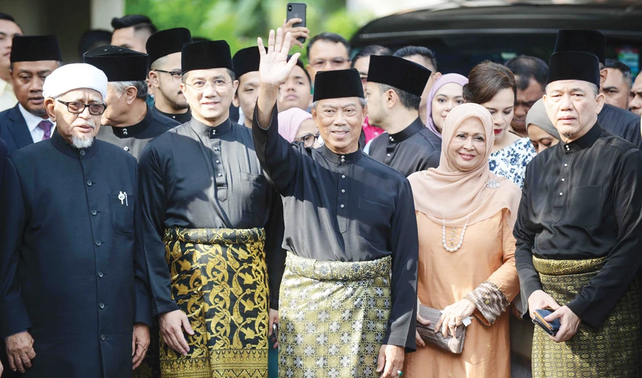Muhyiddin Yassin waves outside his residence in Kuala Lumpur on Sunday before his swearing-in ceremony as Malaysia’s new leader. (AFP)