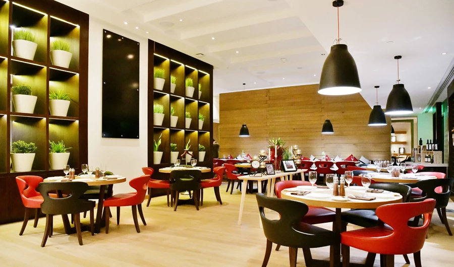 Pesto’s homely ambience is accessorized by patterned floors, wooden accents, family-style seating, and dining areas.