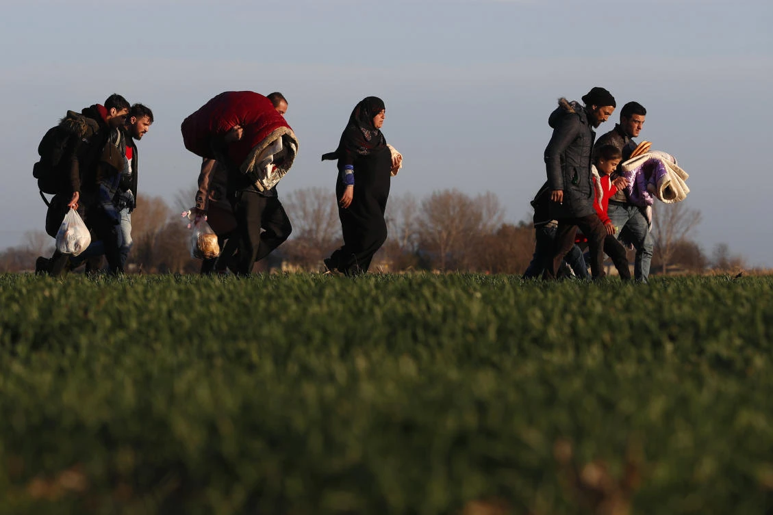 Migrants walk near the Pazarkule border crossing in Edirne, at the Turkish-Greek border on Monday, March 2, 2020. (AP)
