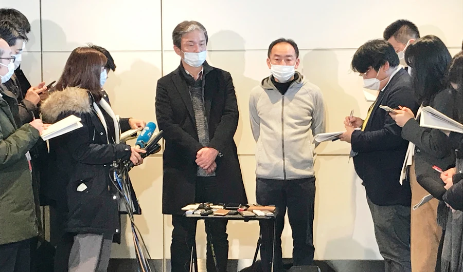 Wearing surgical masks, Takeo Aoyama, center left, and Takayuki Kato, center right, employees at Nippon Steel Corp.’s subsidiary in Wuhan, China, speak to journalists after returning home by a Japanese chartered plane at Haneda international airport in Tokyo Wednesday, Jan. 29, 2020. (AP)