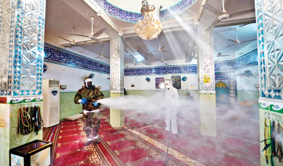 In Iaq’s central shrine city of Najaf, civil defense personnel disinfect on Tuesday a mosque where a confirmed case of novel coronavirus infection, also known as COVID-19, was reported. (AFP)