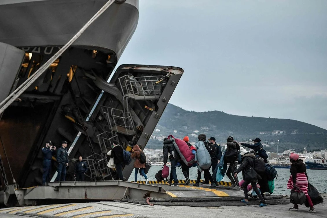 Recently arrived refugees and migrants enter a warship provided for their accommodation at the Port of Mytilene on the Greek island of Lesbos. (AFP)