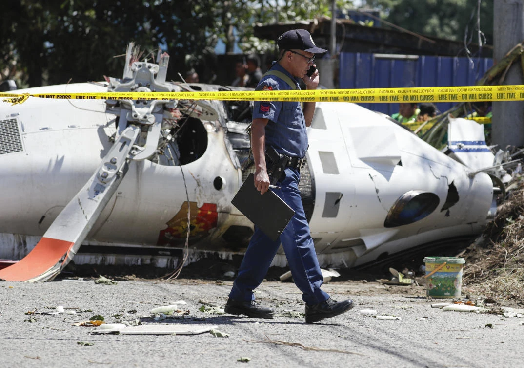 The helicopter was carrying the Philippine national police chief and seven other people when it crashed after hitting a power cable on takeoff. (AP)