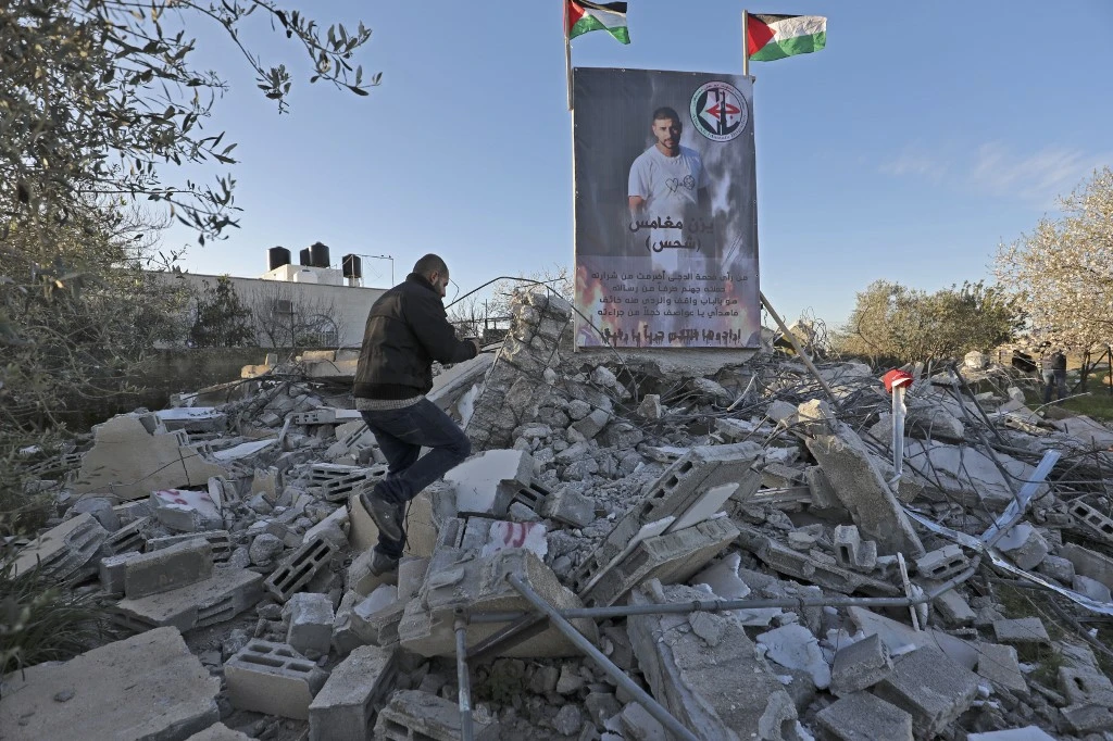 Above, a Palestinian man inspects on March 5, 2020 a house destroyed by the Israeli army in Birzeit. (AFP)