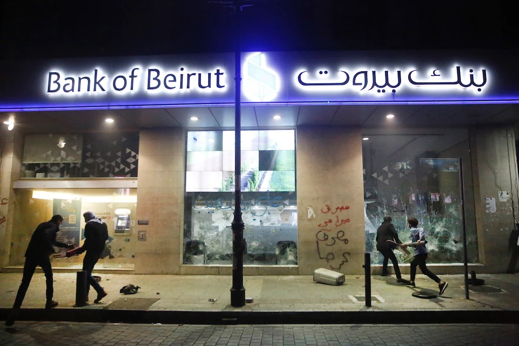 In this Jan. 14, 2020 file photo, anti-government protesters smash bank widows, during ongoing protests against the Lebanese central bank's governor, on Hamra Street, in Beirut, Lebanon. (AP)