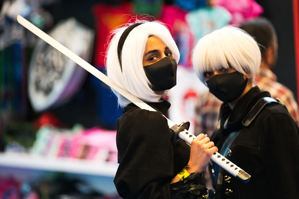Two women wearing masks dressed as sword-wielding anime characters pose for a photograph at the Middle East Film & Comic Con in Dubai, United Arab Emirates, March 5, 2020. (AP Photo)