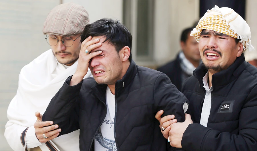 Afghan men cry at a hospital in Kabul after they heard that their relative was killed during Friday’s attack that targeted a Shiite political gathering. (Reuters)