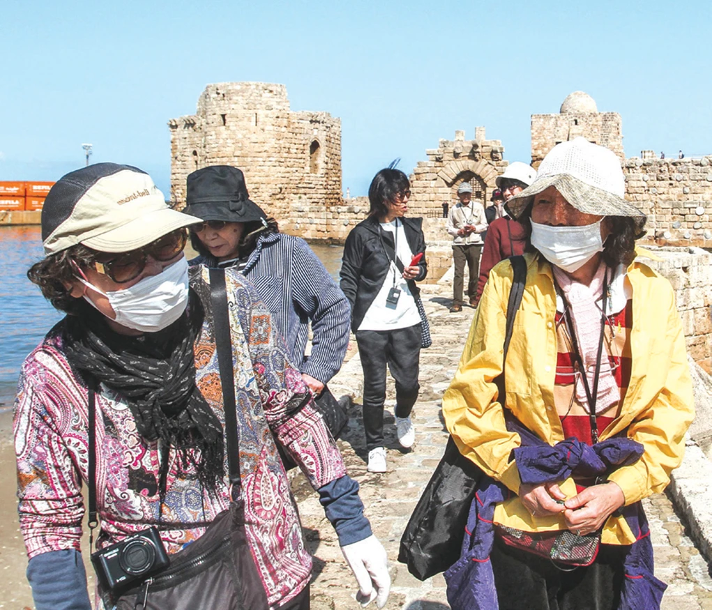 Japanese tourists wearing health masks, due to fears of coronavirus, tour in the Sidon Sea Castle in the southern Lebanese city of Sidon on Saturday. (AFP)