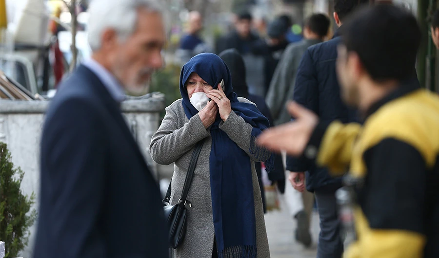 An Iranian woman wears a protective face mask, following the coronavirus outbreak, as she talks on the phone, in Tehran. (Reuters)