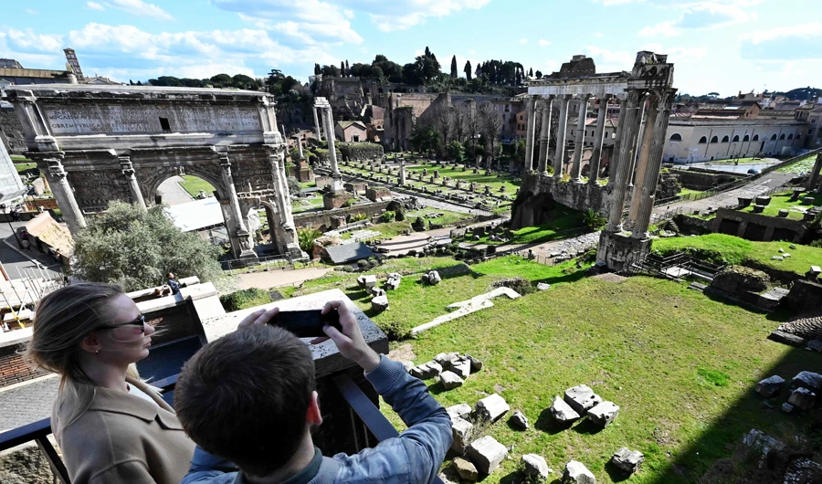 Tourists take pictures of the closed Ancient Forum from the outside on March 8, 2020, in Rome, after millions of people were placed under forced quarantine in northern Italy as the government approved drastic measures in an attempt to halt the spread of the COVID-19 outbreak, caused by the novel coronavirus that is sweeping the globe. (AFP)