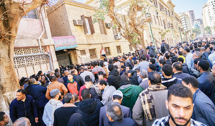 Egyptians who are traveling abroad in the next 24 hours gather to get a coronavirus test, in front of the Central Public Health Laboratories, in Cairo, on Sunday. (AP)