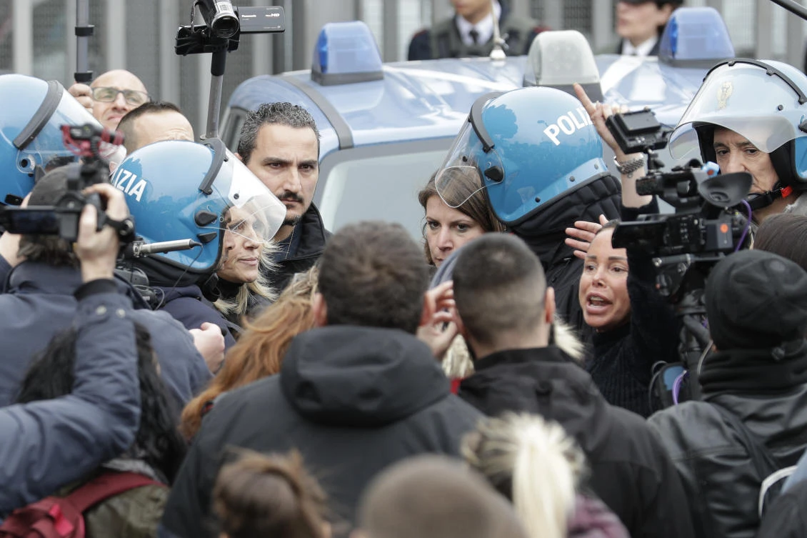 Relatives of Rebibbia prison's inmates face police after inmates staged a protest against new coronavirus containment measures, in Rome, Monday, March 9, 2020. (AP)
