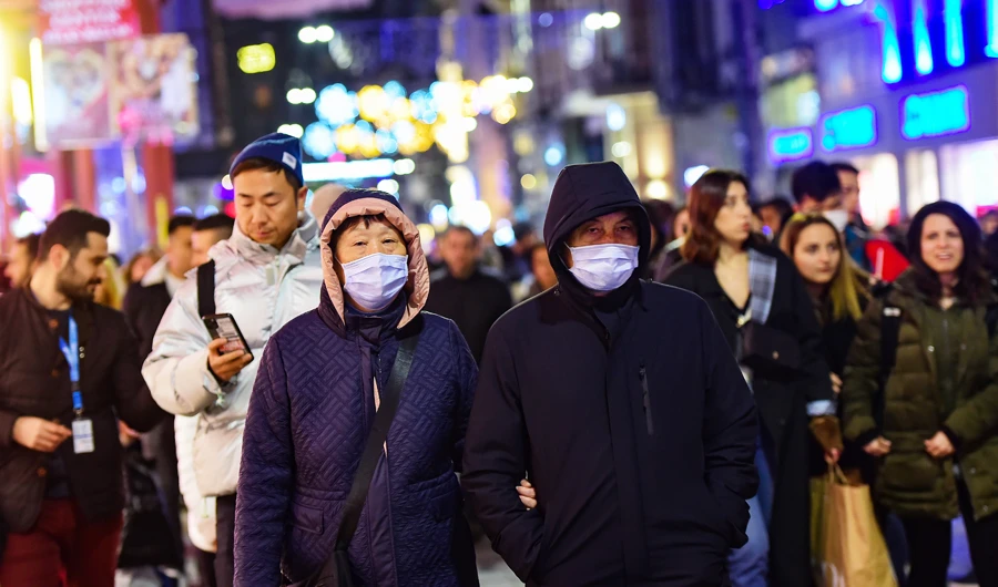 Asian tourists wearing protective masks as they walks in Istiklal street in Istanbul , on January 31, 2020. (AFP)
