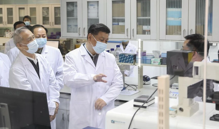 In this photo released by Xinhua News Agency, Chinese President Xi Jinping, centre, wearing a protective face mask, talks to a medical staff member during his visit to the Academy of Military Medical Sciences in Beijing on March 2, 2020. (AP)
