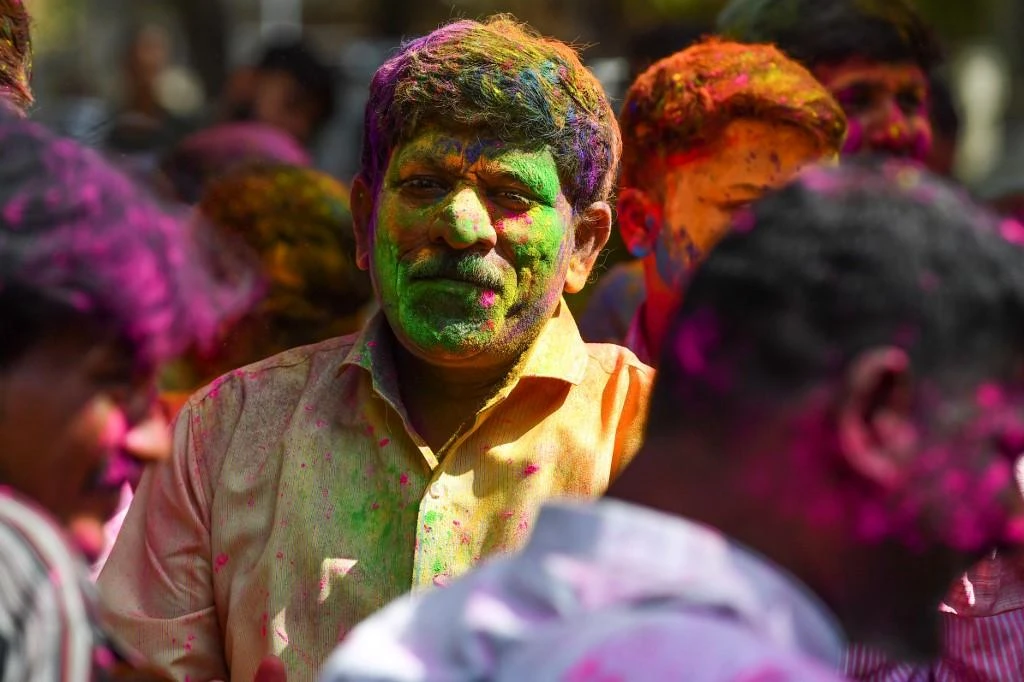 India’s two-day spring festival is a rowdy explosion of color, with people smearing each other’s faces with green, yellow and red powder. (AFP)