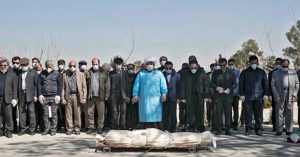 Mourners wearing face masks and gloves perform funeral prayer for the person who died on Monday after being infected with the new coronavirus in Tehran on March 10, 2020. (Tasnim News Agency via AP)