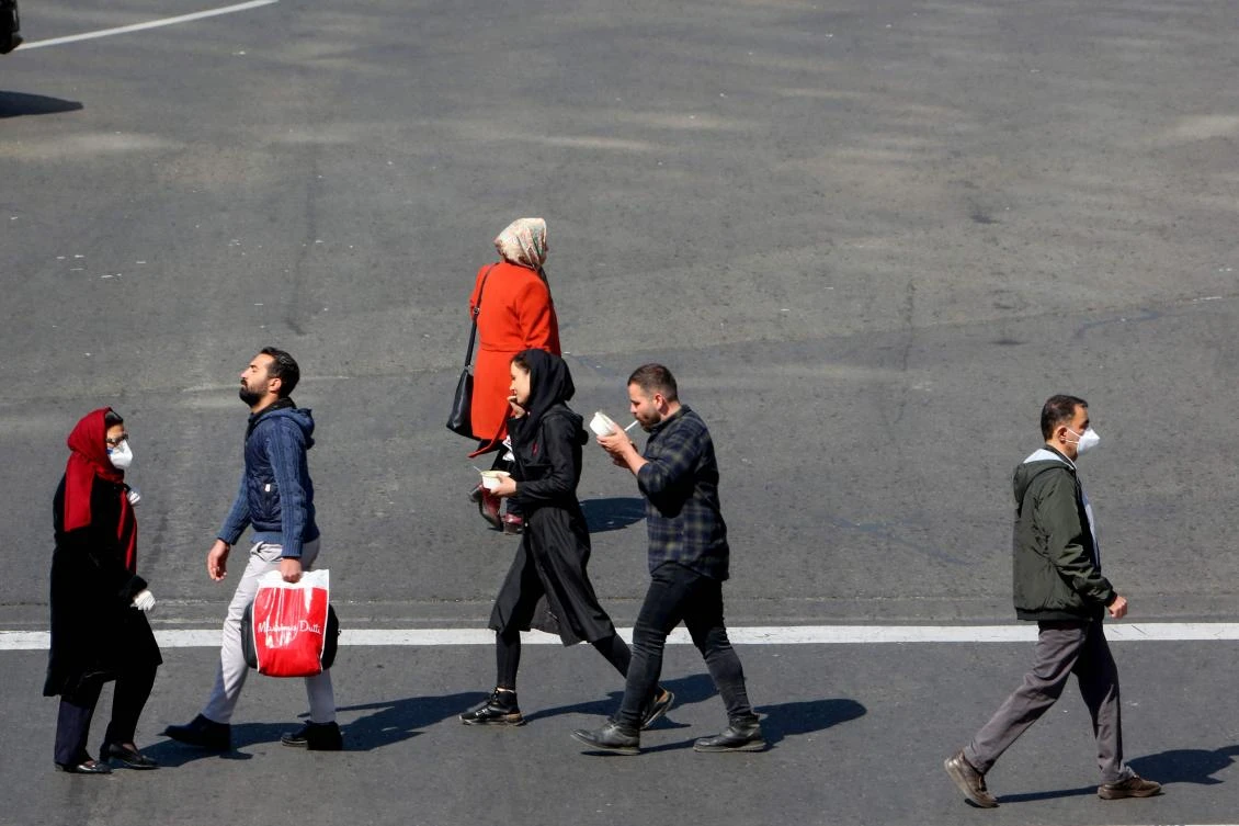 Iranian pedestrians cross a street while wearing protective masks in Tehran on March 10, 2020 amid the spread of coronavirus in the country. Iran today reported 54 new deaths from the novel coronavirus in the past 24 hours, the highest single-day toll since the start of the country's outbreak. (AFP)