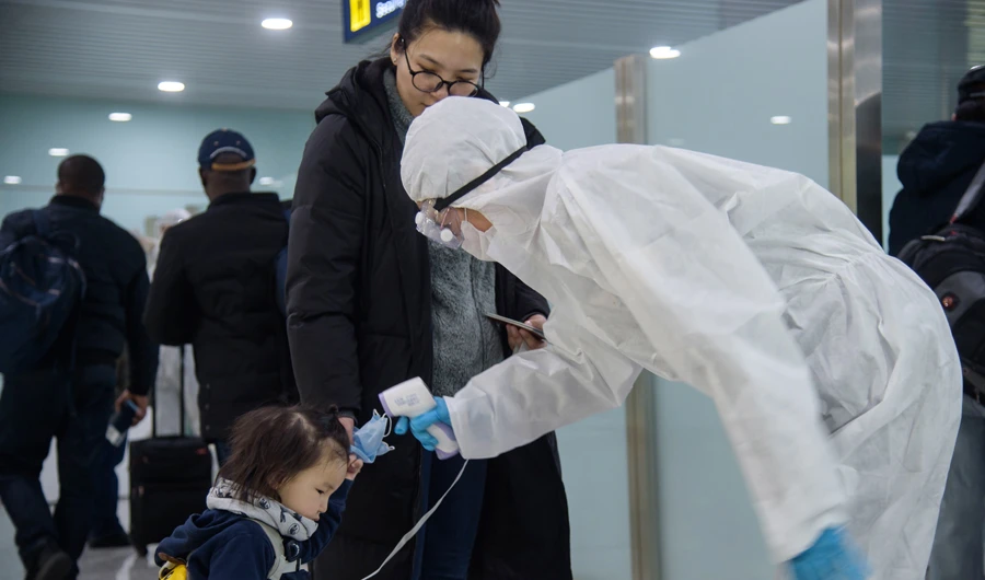 A child has her temperature taken as foreign diplomats and embassy staff prepare to board a flight to Vladivostok at Pyongyang International Airport on March 9, 2020. (AFP)