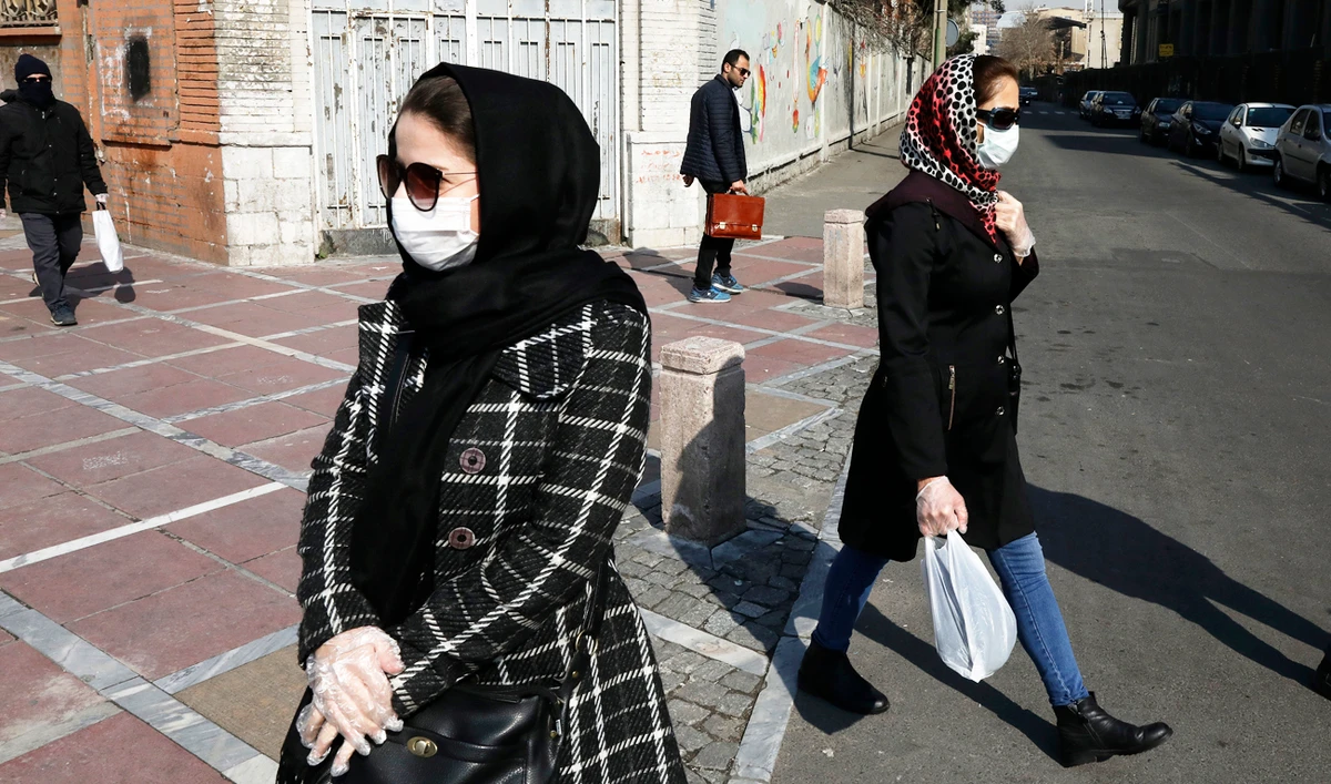 Pedestrians walk as some of them wear masks in downtown Tehran, Iran. (AP)