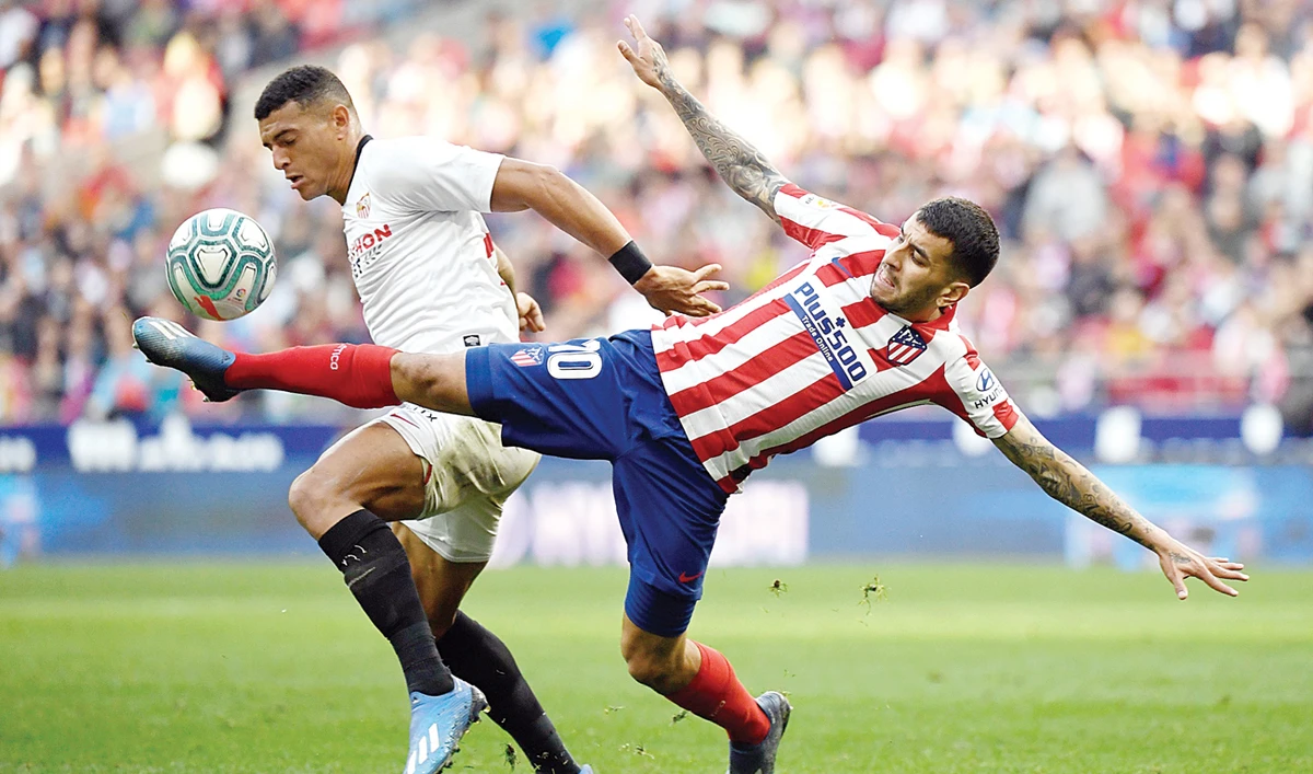 Sevilla’s Brazilian defender Diego Carlos, left, vies with Atletico Madrid’s Argentine forward Angel Correa during a football match in Madrid on Saturday. (AFP)